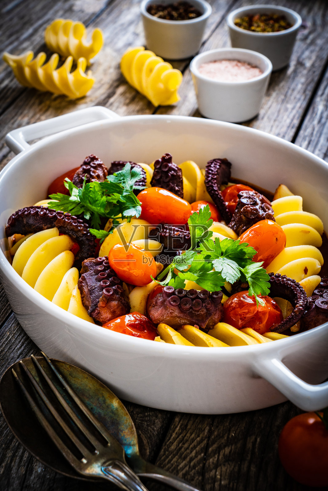 木桌上的烤章鱼和蔬菜通心粉照片摄影图片