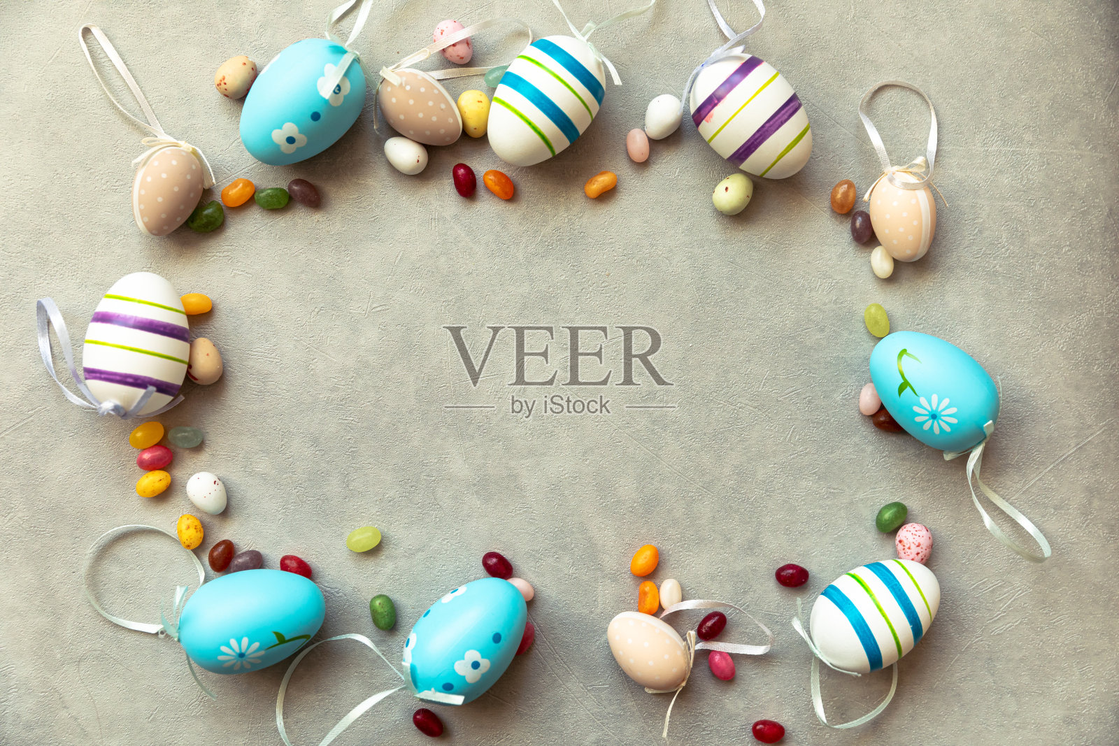 复活节快乐的概念。为假期做准备。复活节彩蛋糖果巧克力蛋和果冻豆糖果在混凝土石头灰色背景。平躺顶视图复制空间横幅照片摄影图片