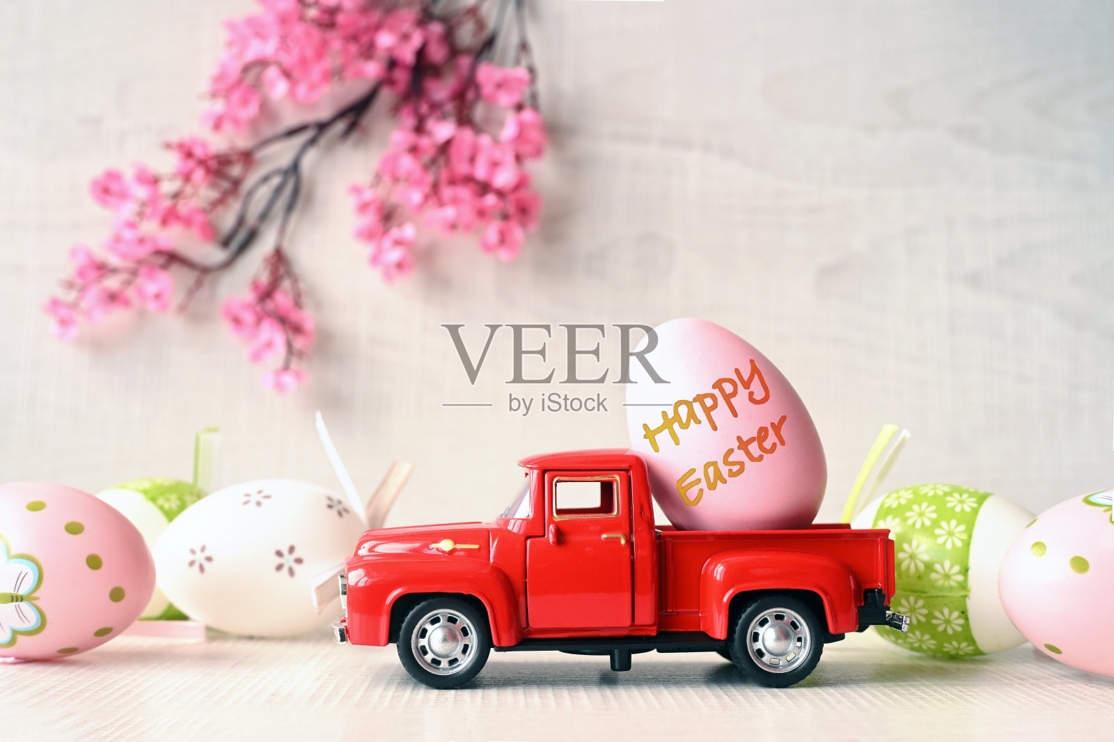 一个复活节彩蛋放在一辆小车上，背景很亮，枝繁叶茂。副本的空间。照片摄影图片