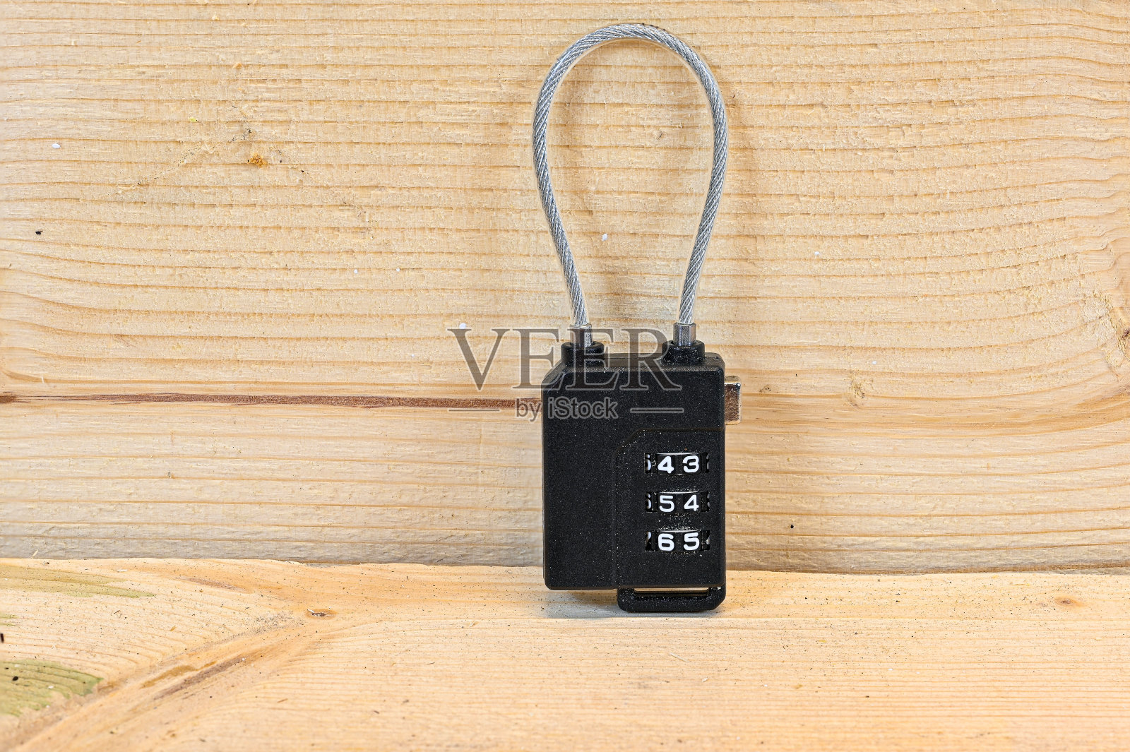 木凳上装有铁丝的小密码锁照片摄影图片