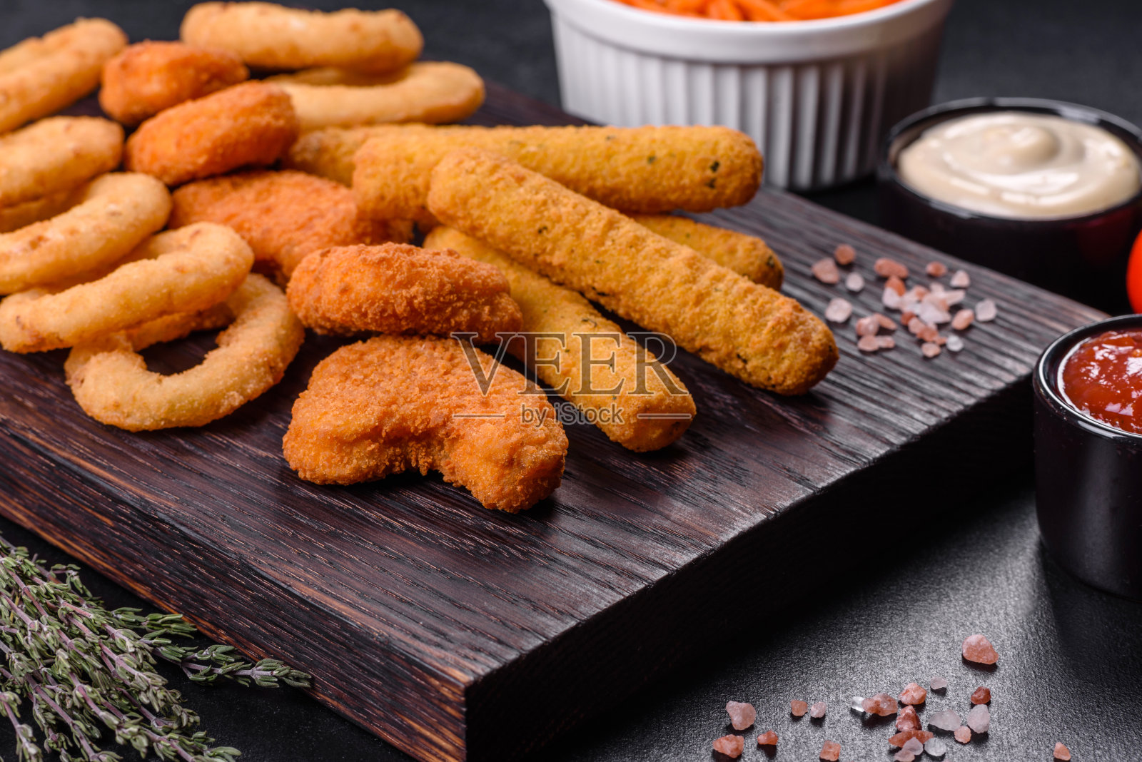 小吃拼盘-芝士条，鸡块，洋葱圈混合小吃和酱料照片摄影图片