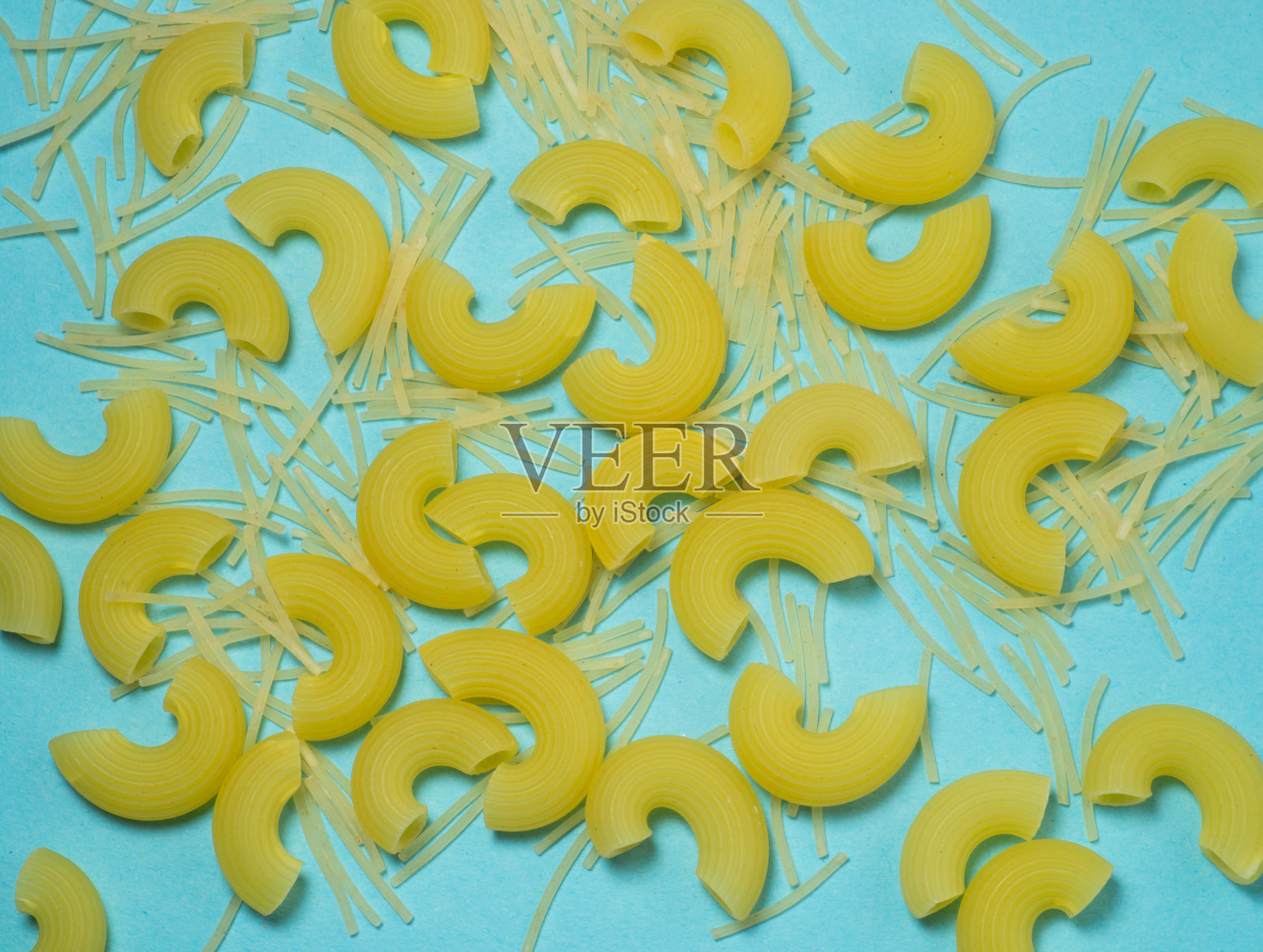不同类型的意大利面在蓝色的背景上。照片摄影图片