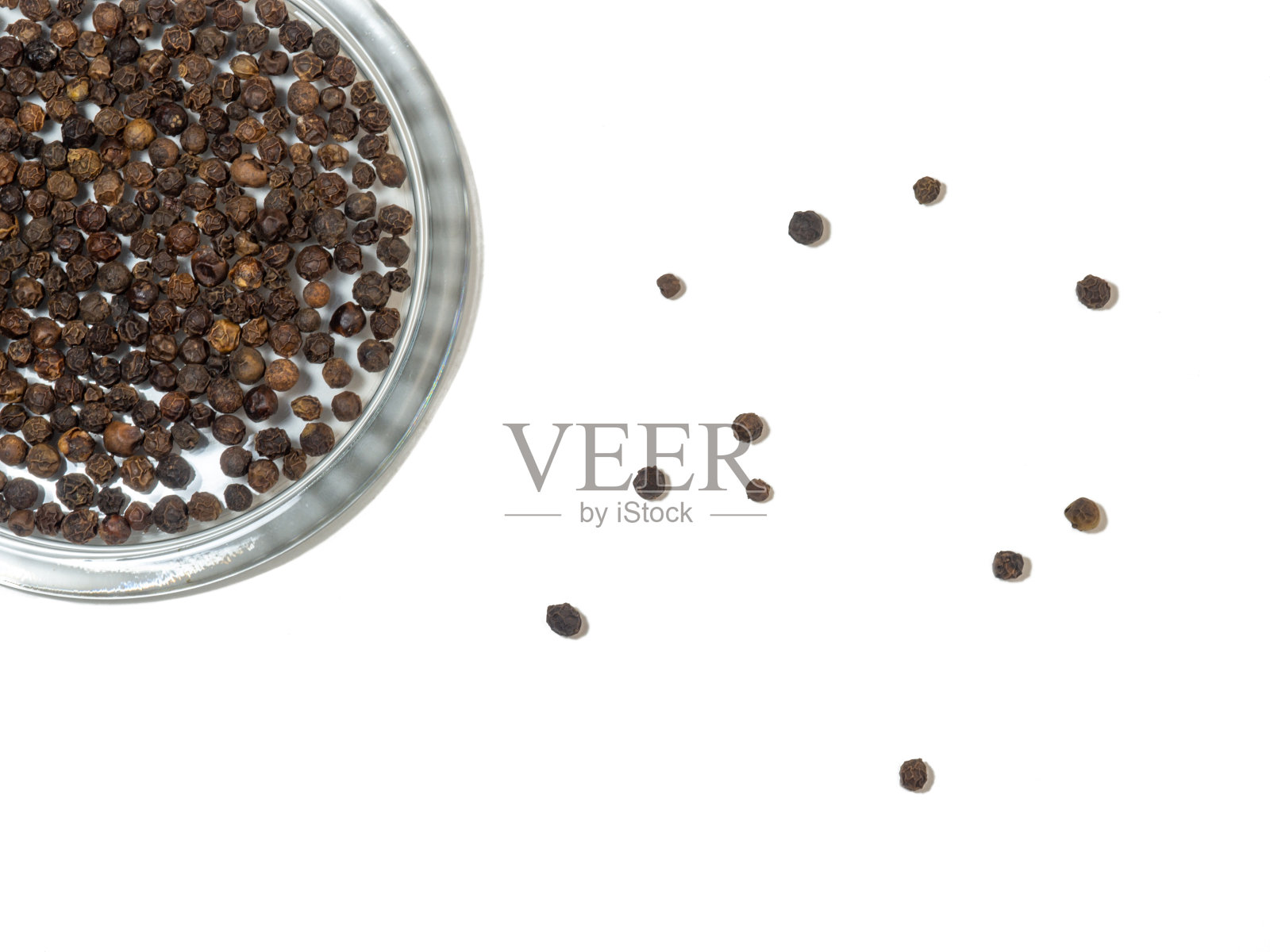 黑胡椒粒，白色背景，玻璃盘。照片摄影图片