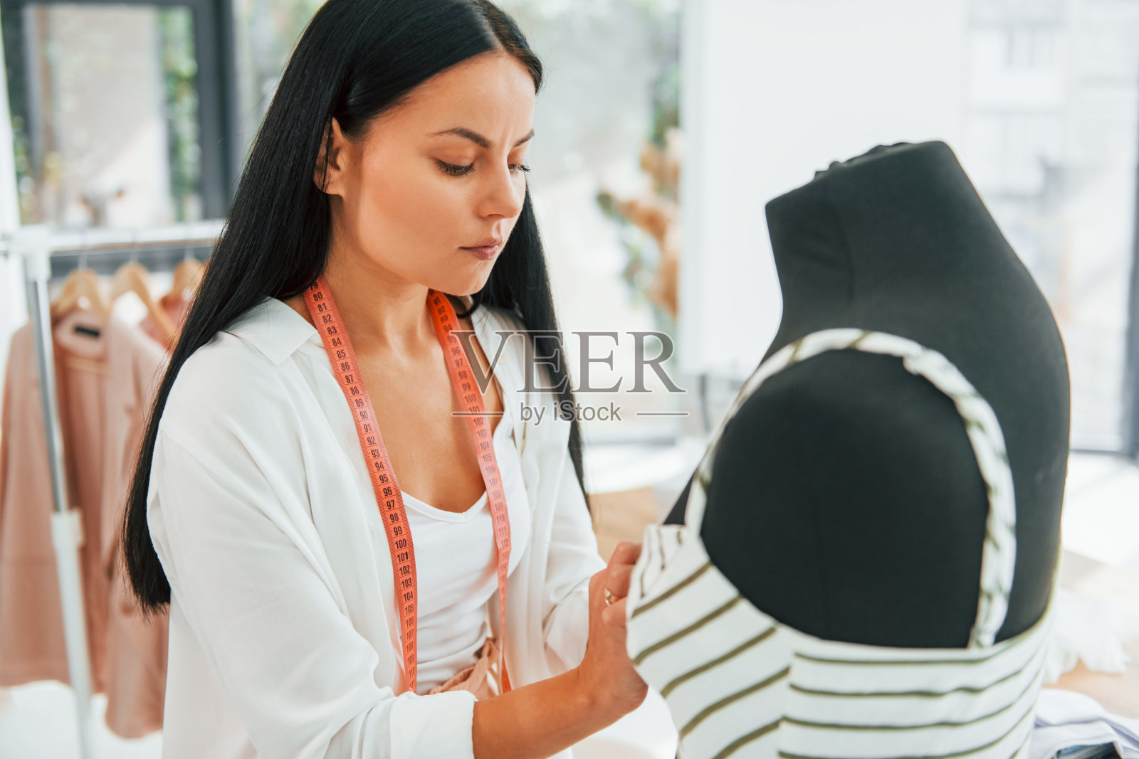 测量衣服。女裁缝在她的办公室照片摄影图片