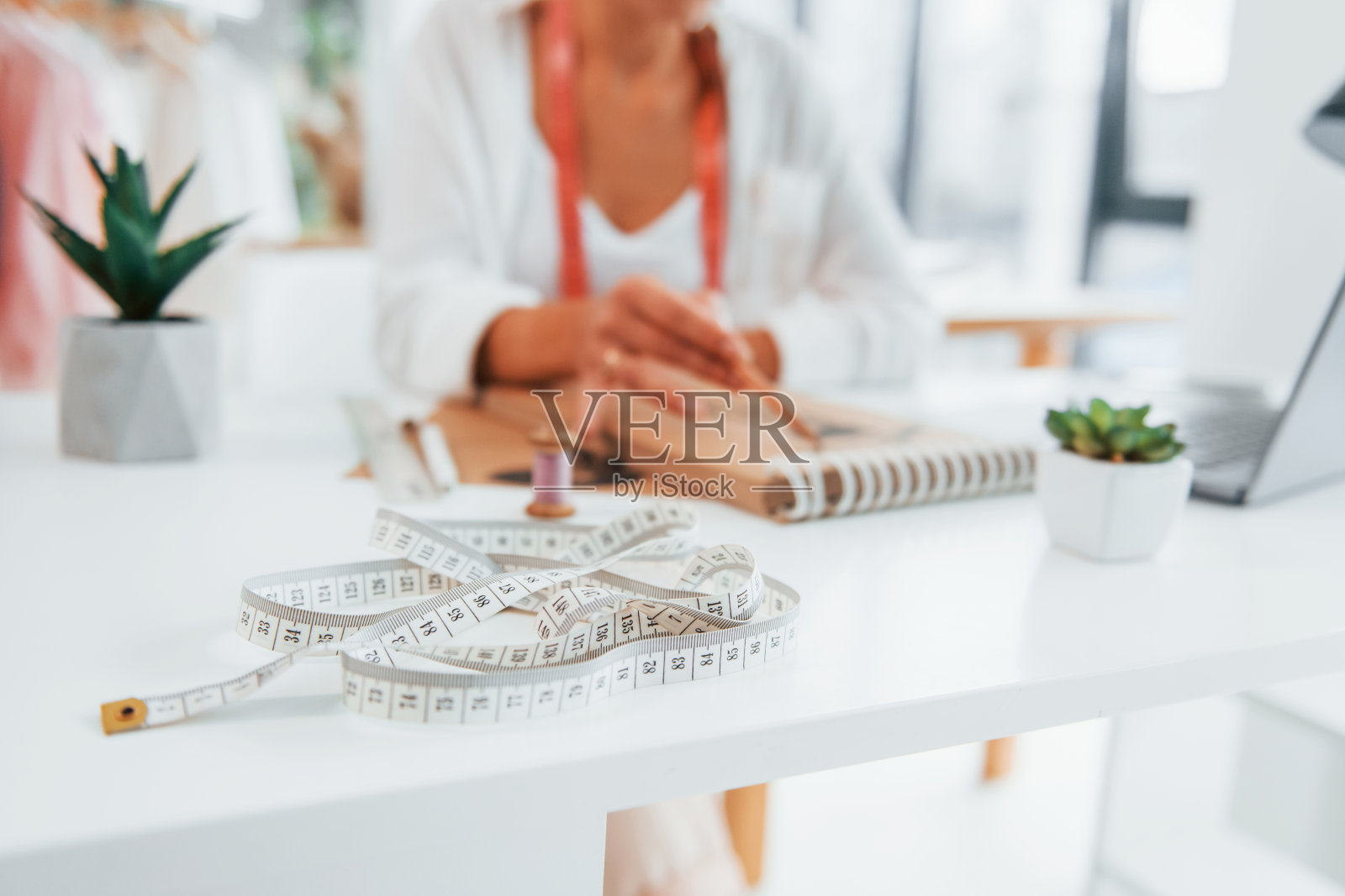 关闭视图。女裁缝在她的办公室里穿着不同的衣服照片摄影图片