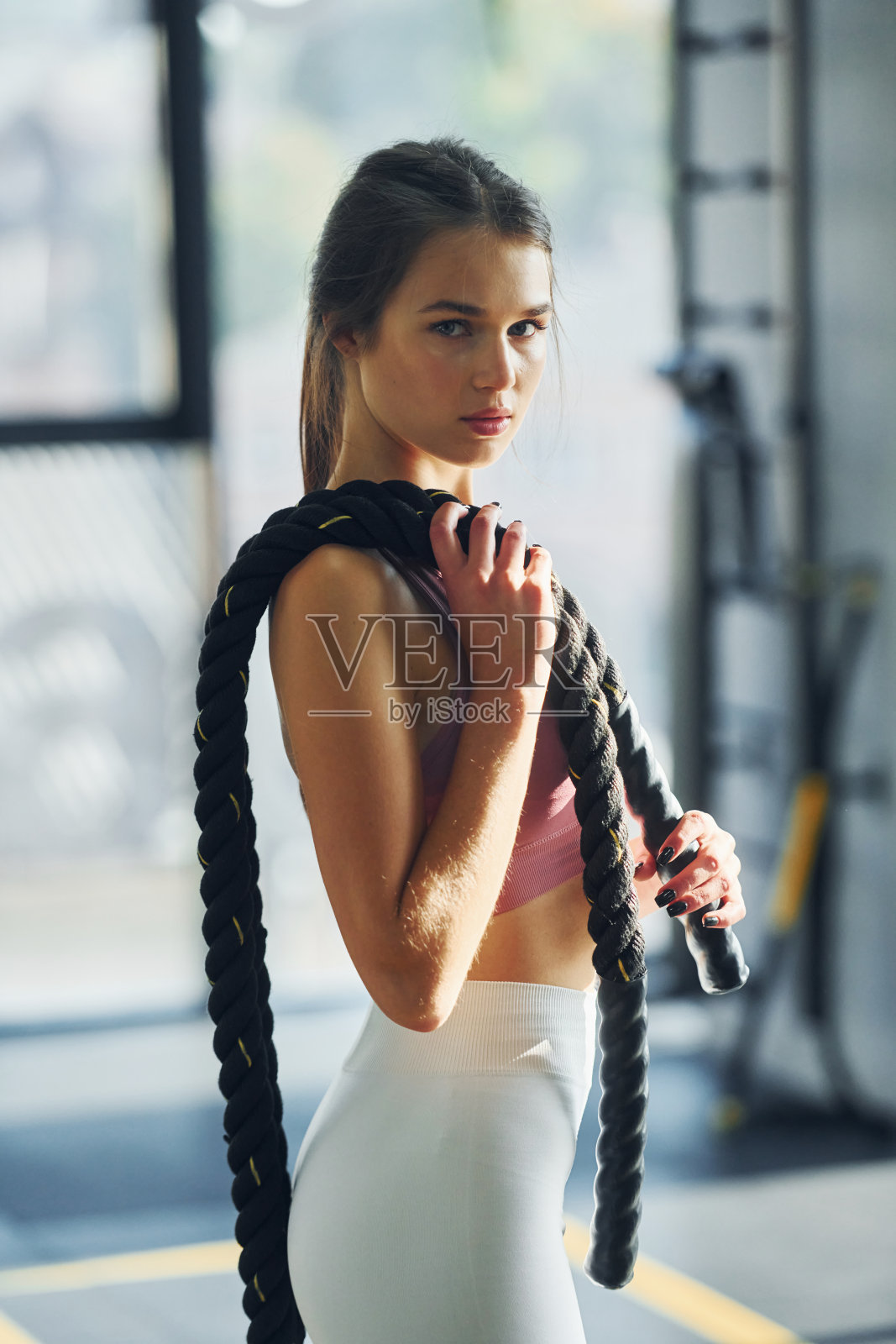 侧视图。身材苗条的漂亮年轻女子正在健身房里照片摄影图片