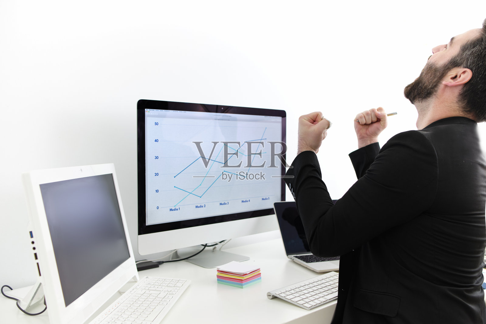 一个年轻人坐在电脑前庆祝销售业绩和职业成就照片摄影图片