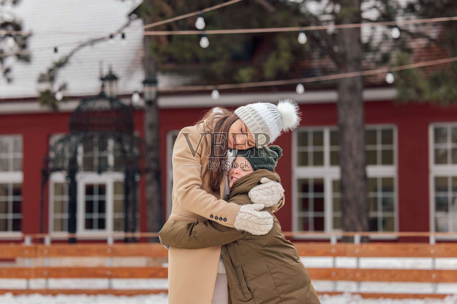 带着儿子的单亲妈妈，互相给予爱，享受滑冰的乐趣。照片摄影图片