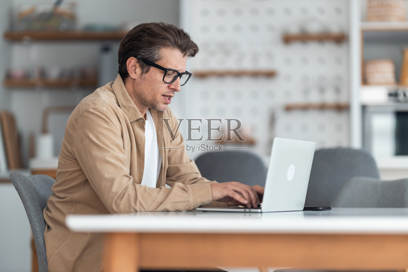 男性企业家在家里的办公室用笔记本电脑打电子邮件。照片摄影图片