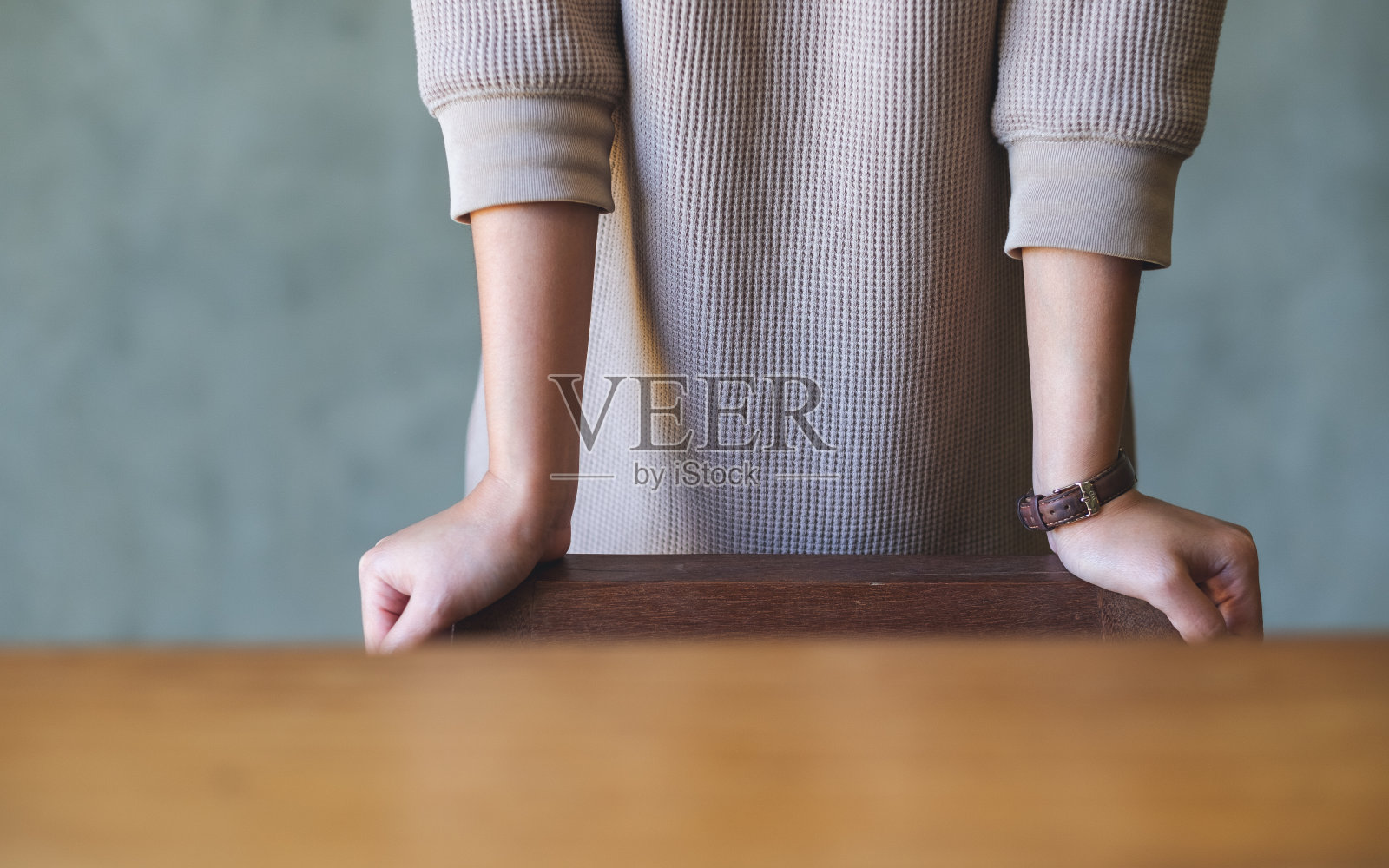 特写图像的一个女人站和休息的手在木椅上照片摄影图片