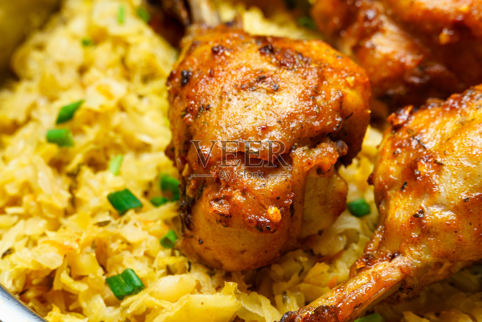 在煎锅里炸鸡腿，配上炖白菜，以乡村风格的烹饪食物为背景照片摄影图片