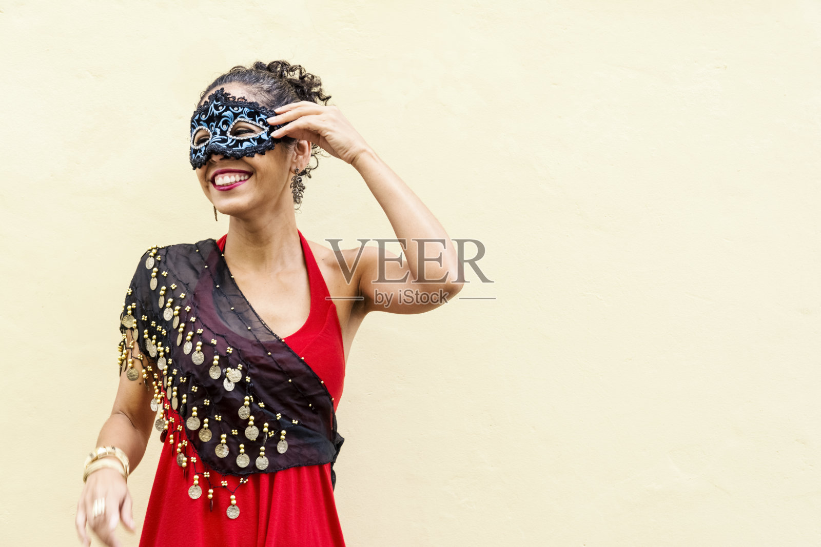 在灯光背景下，一个女人戴着威尼斯狂欢节面具的肖像。照片摄影图片