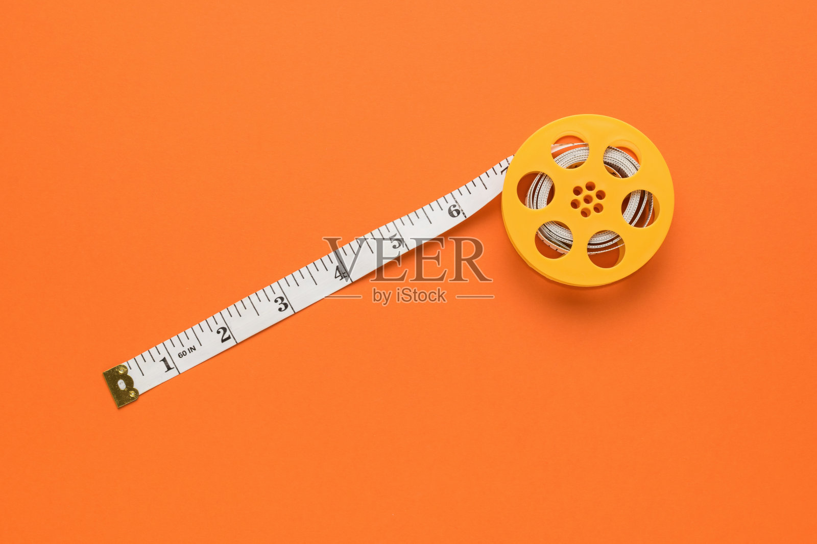 在橙色背景上对角展开卷尺。平的。照片摄影图片