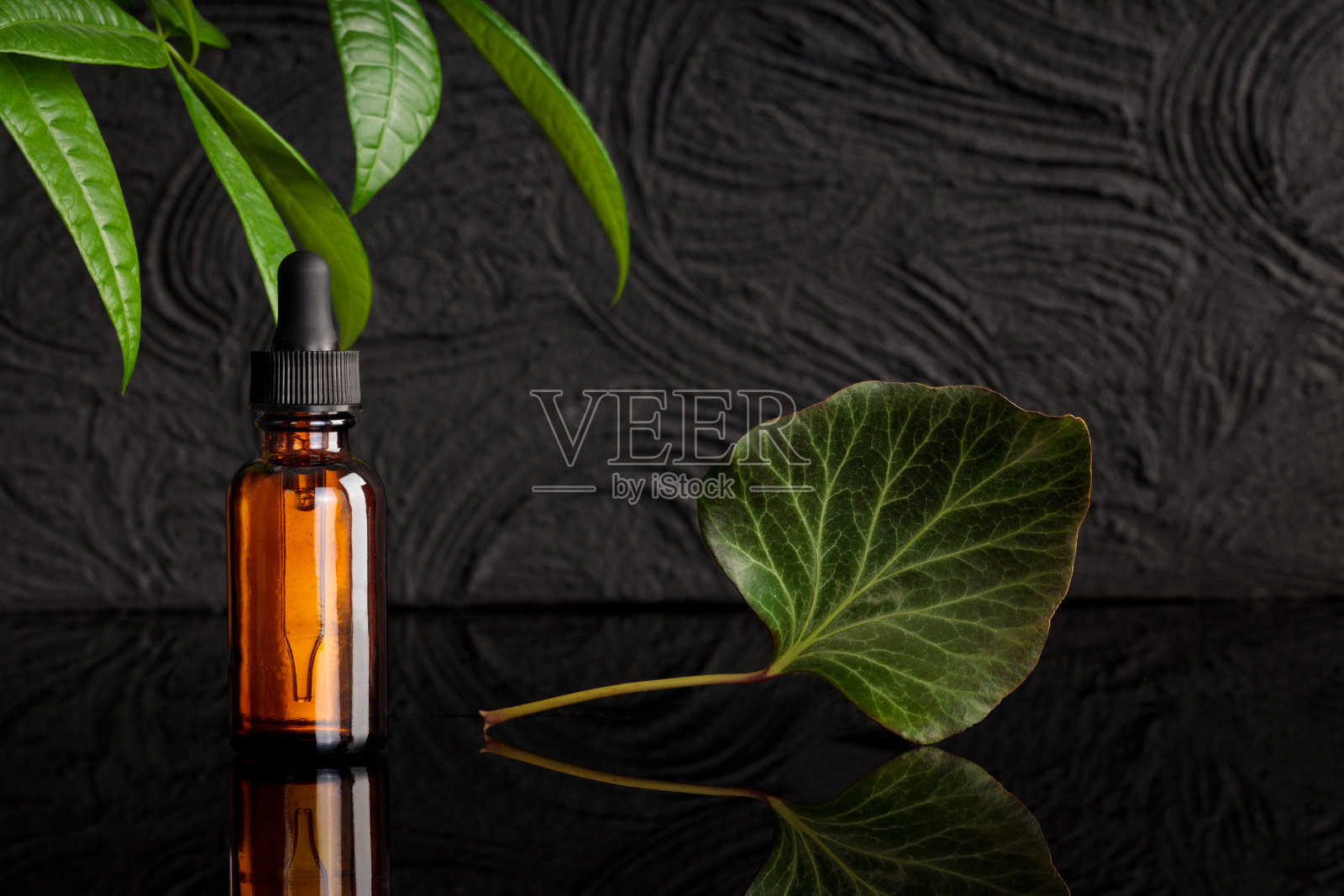 天然药用油。吸液管带油，瓶子黑色背景。照片摄影图片