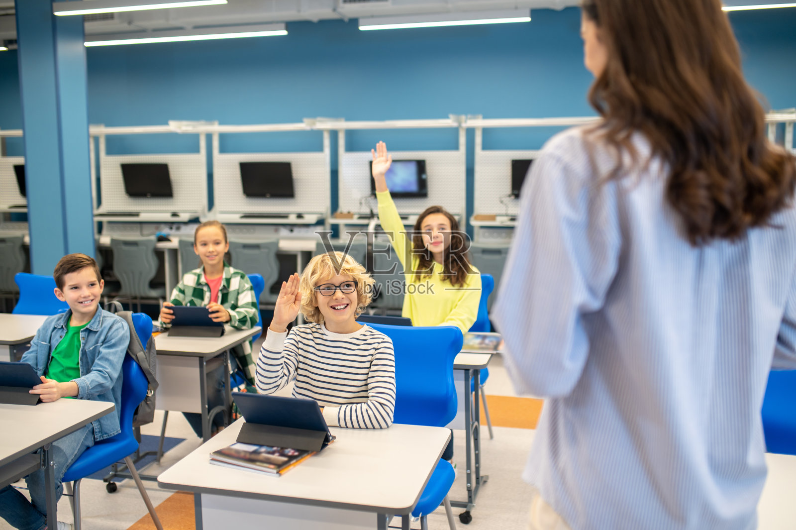 孩子们举手看着老师照片摄影图片