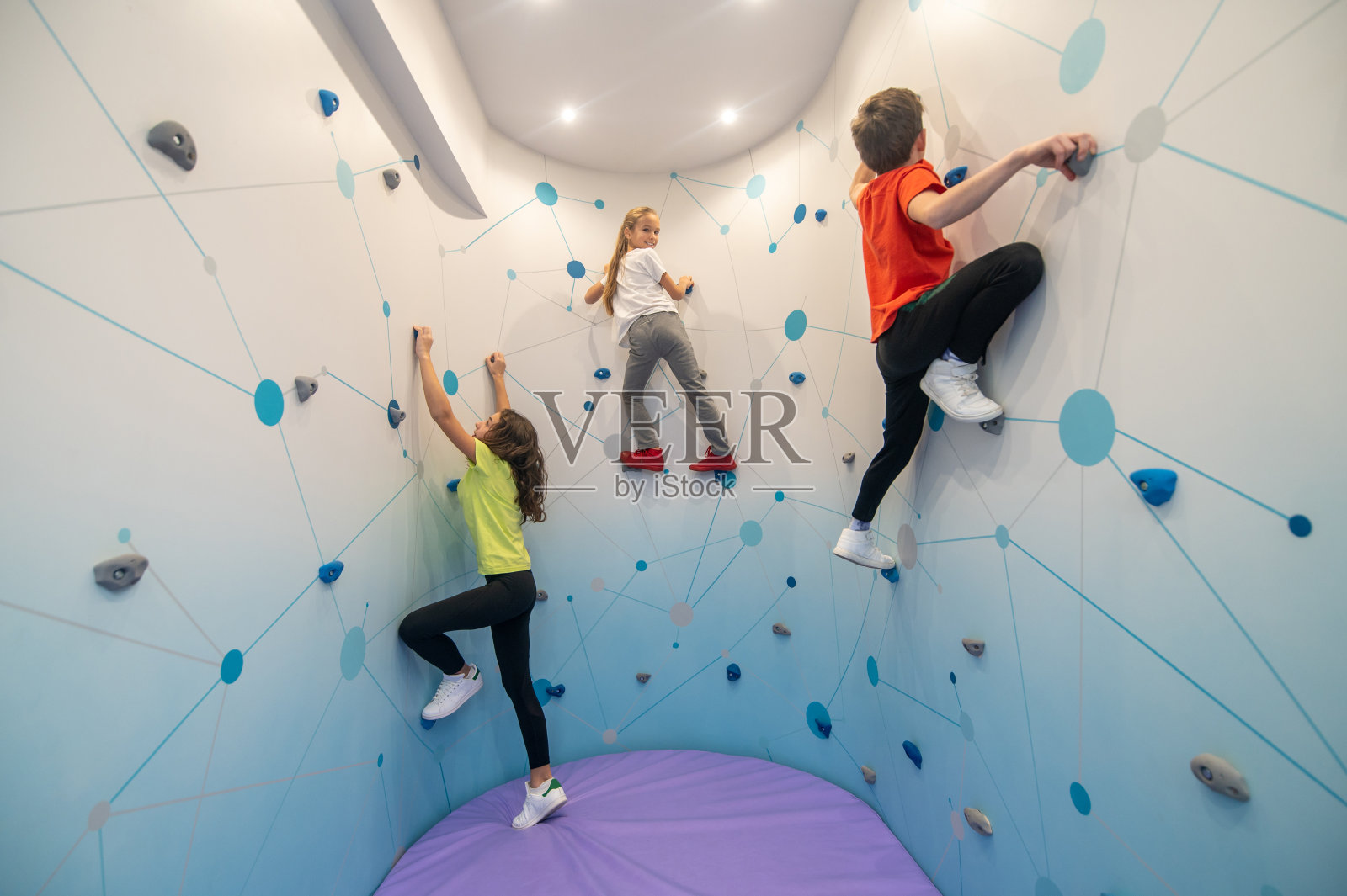 两个女孩和男孩在练习爬墙照片摄影图片