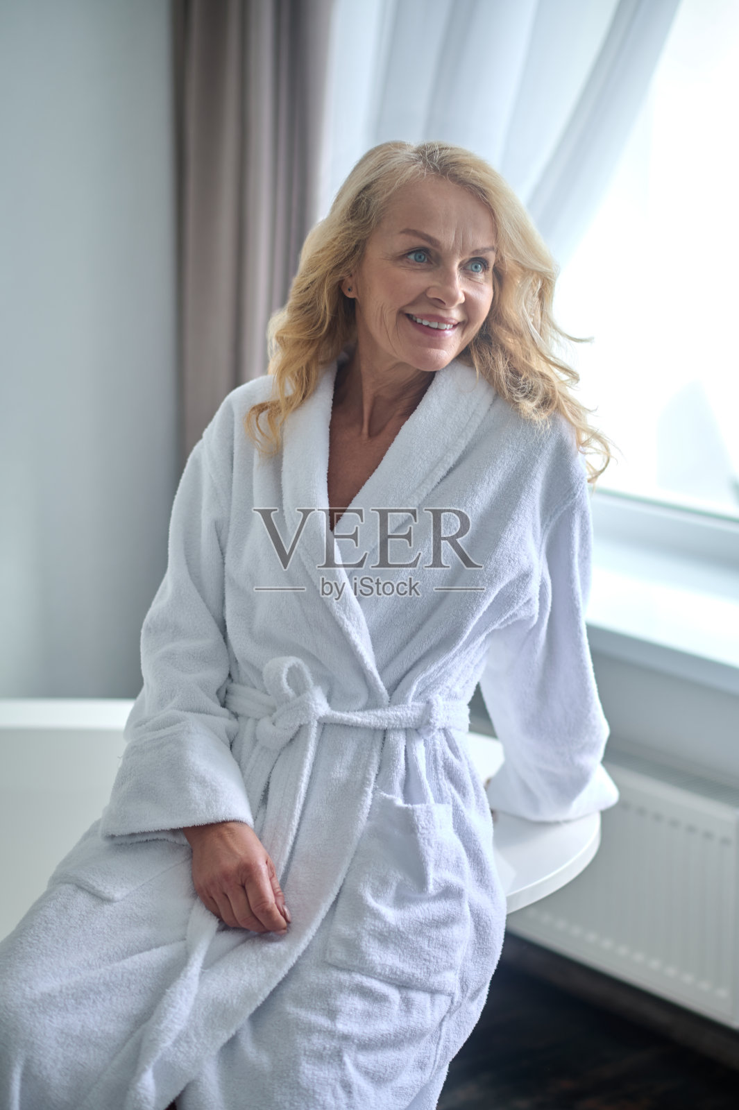 一个穿着白袍的金发中年女人照片摄影图片