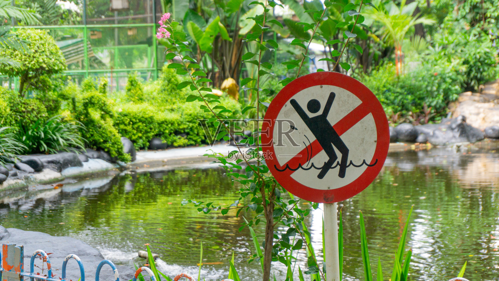 有溺水危险的警告标志。红色圆形标志的插图与下沉的人。注意，城市公园水位高照片摄影图片