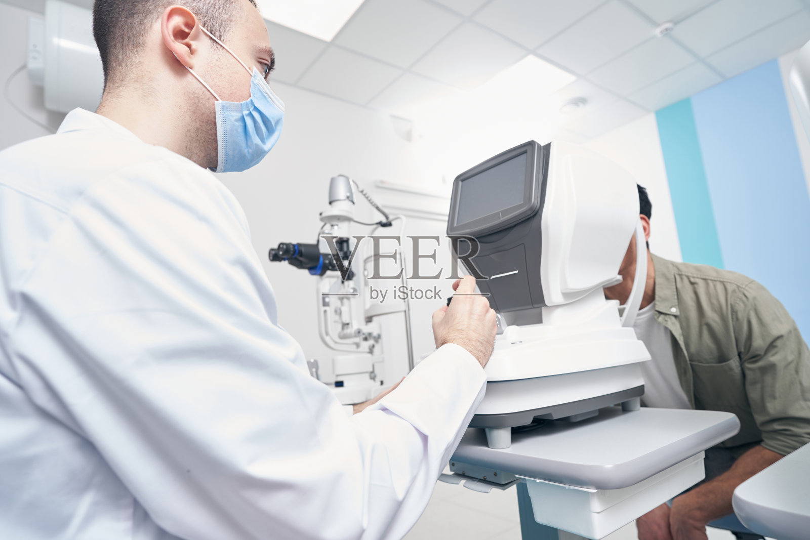 专业医生在验光机旁工作照片摄影图片