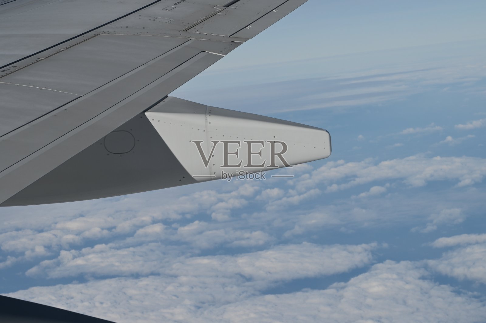 一架波音737飞机机翼下的发动机，下方可以看到蓝天和白云照片摄影图片