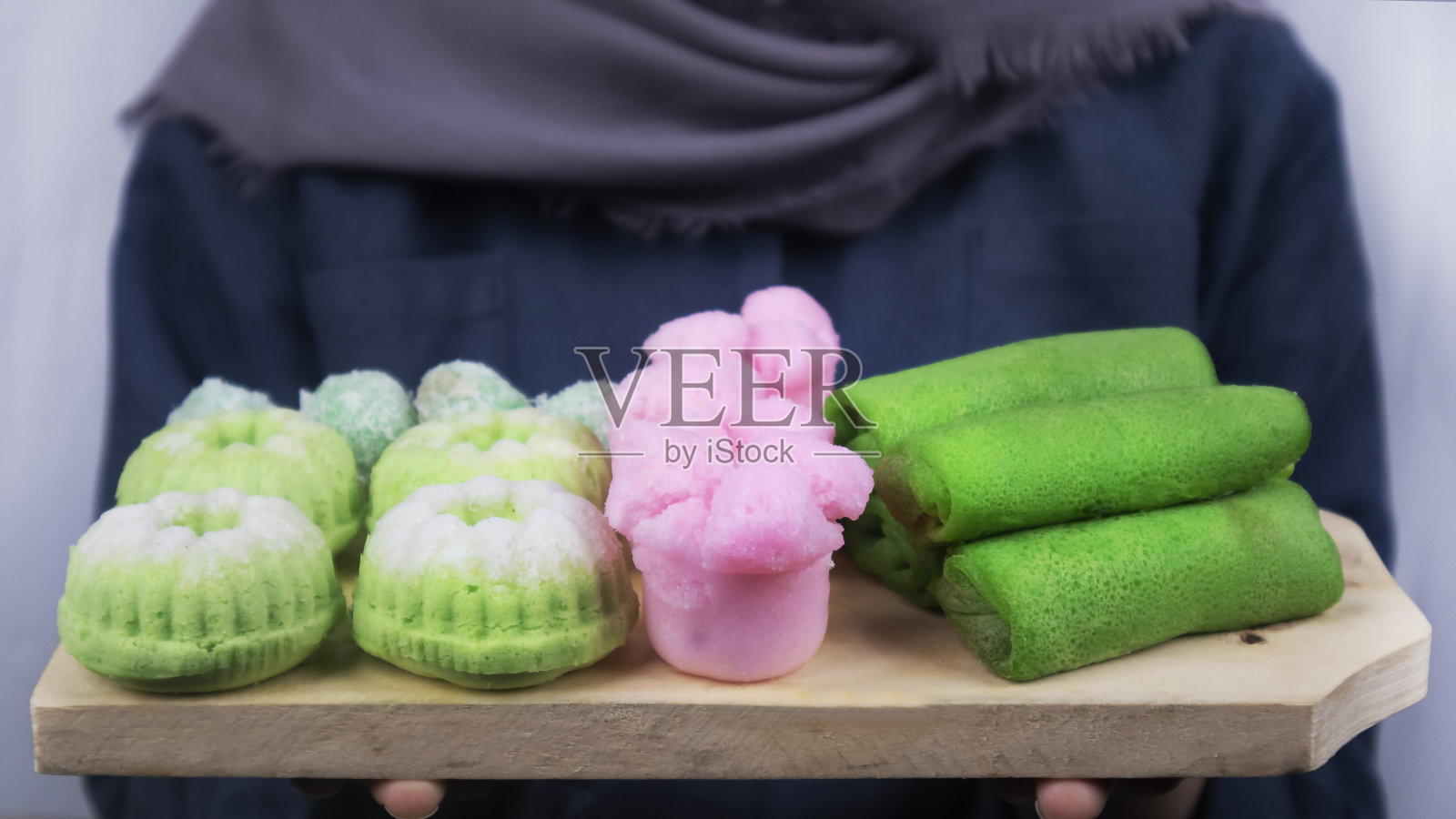 一个女孩手里拿着一块装满印度市场小吃的木板照片摄影图片