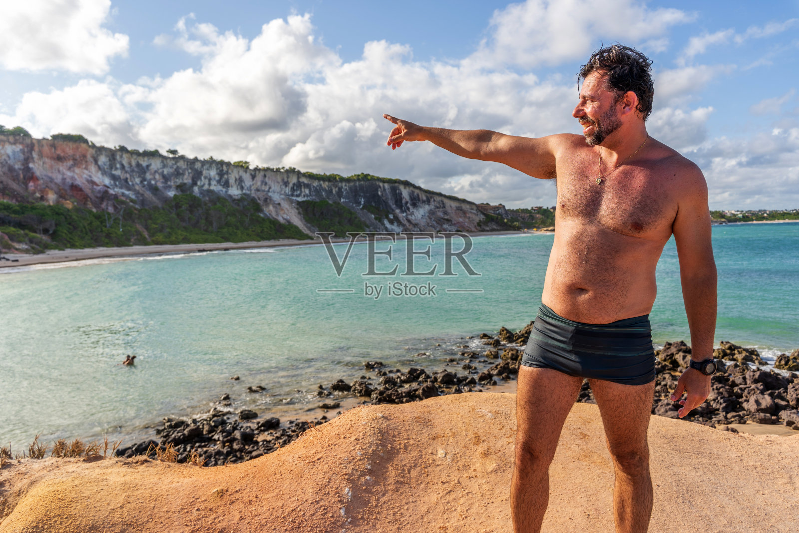 英俊的巴西男子站在沙滩沙丘岩石照片摄影图片