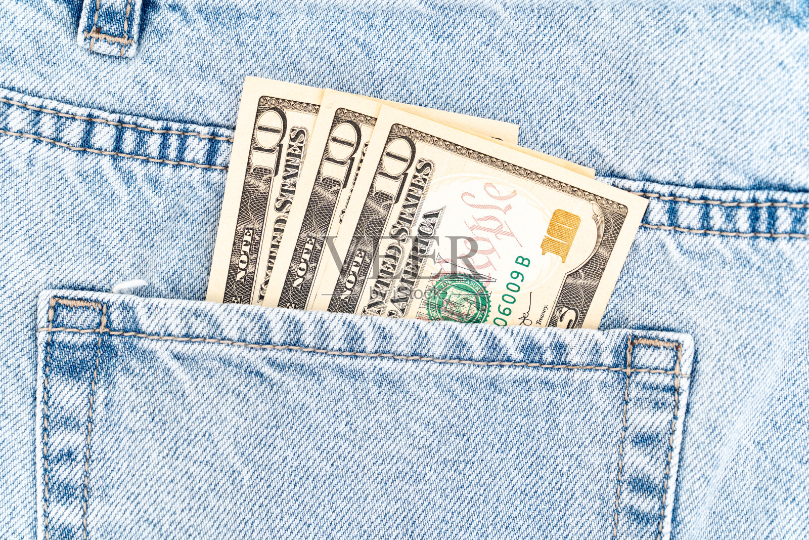 蓝色牛仔裤口袋里的钞票。十美元钞票。照片摄影图片