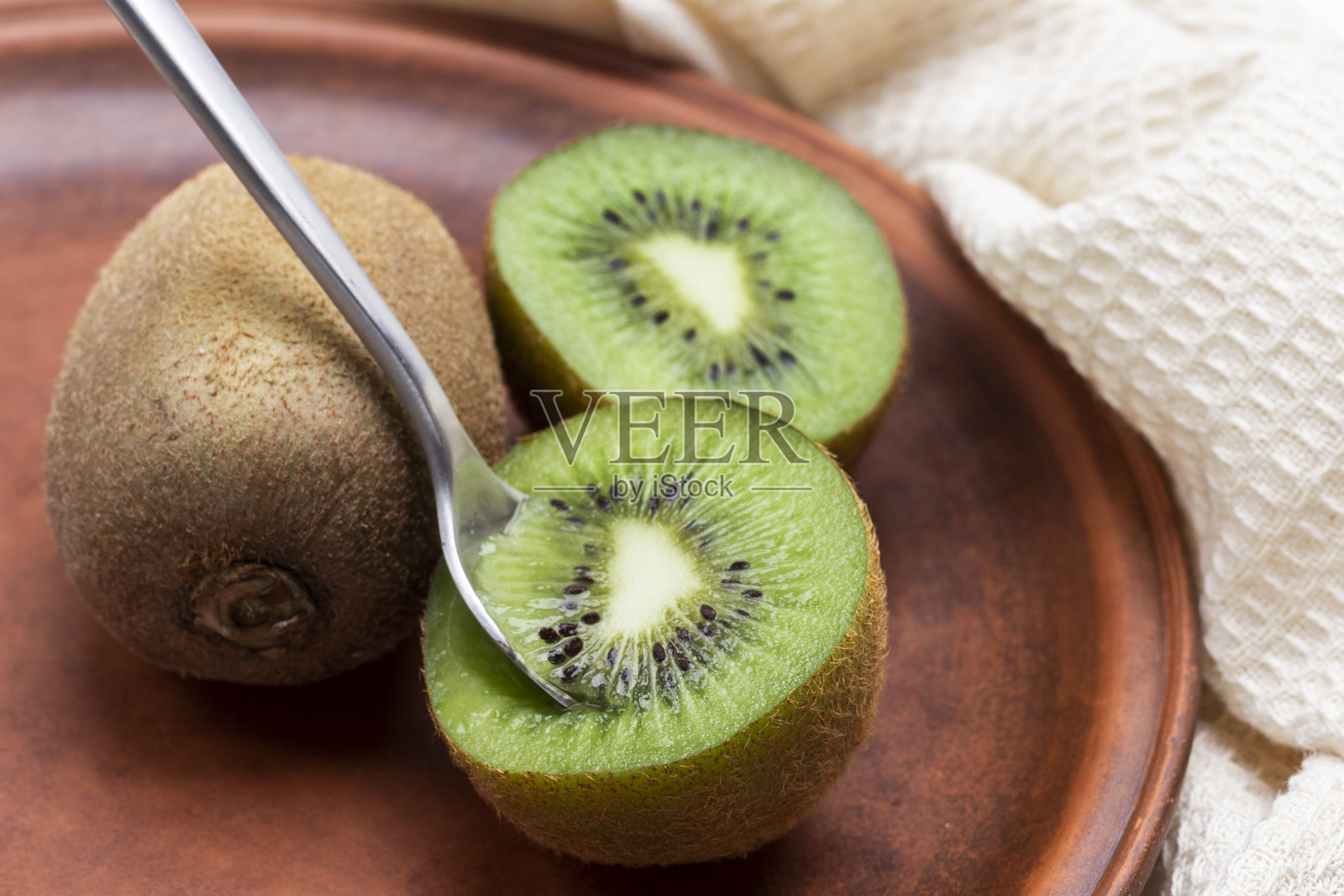 舀一勺猕猴桃果肉。照片摄影图片