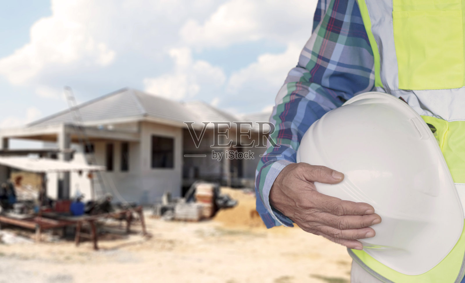 工人头戴安全帽，身穿绿色安全服照片摄影图片