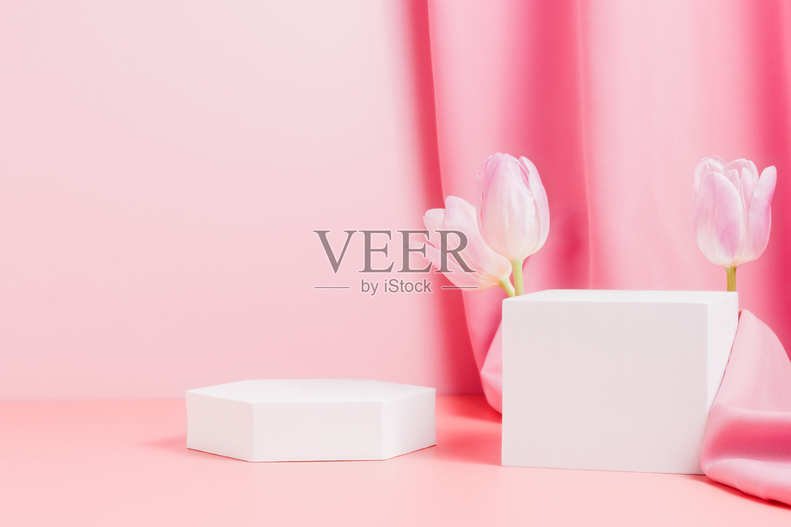用郁金香和粉红色织物装饰的几何型讲台照片摄影图片