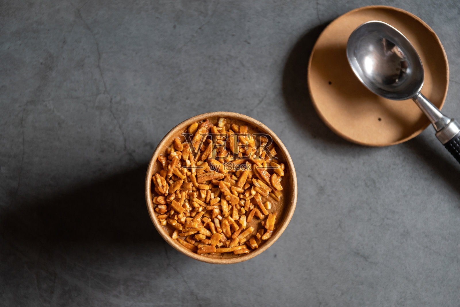 桶容器的咖啡杏仁冰淇淋与充分的杏仁在上面孤立的灰色背景。照片摄影图片