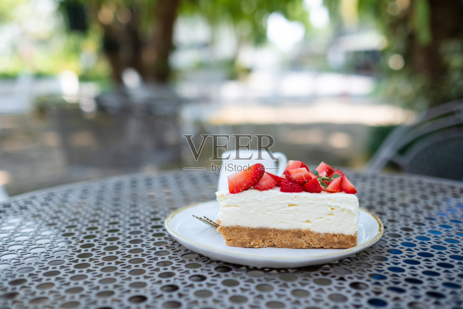 桌上有一块草莓芝士蛋糕照片摄影图片