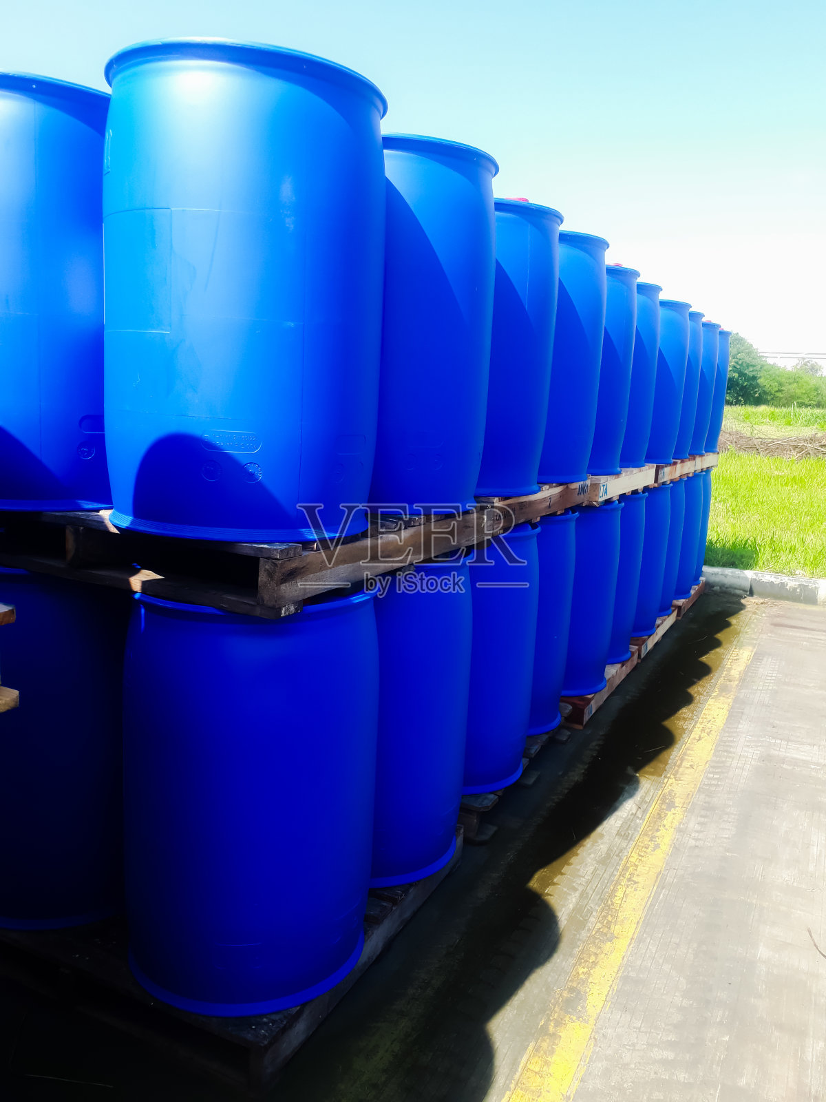 蓝桶化学品:200公斤，放在户外仓库的木托盘上照片摄影图片