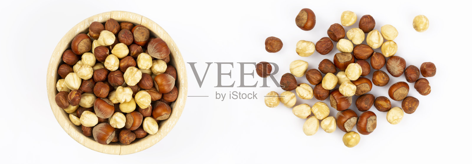 坚果在碗里和地板上，白色的背景照片摄影图片