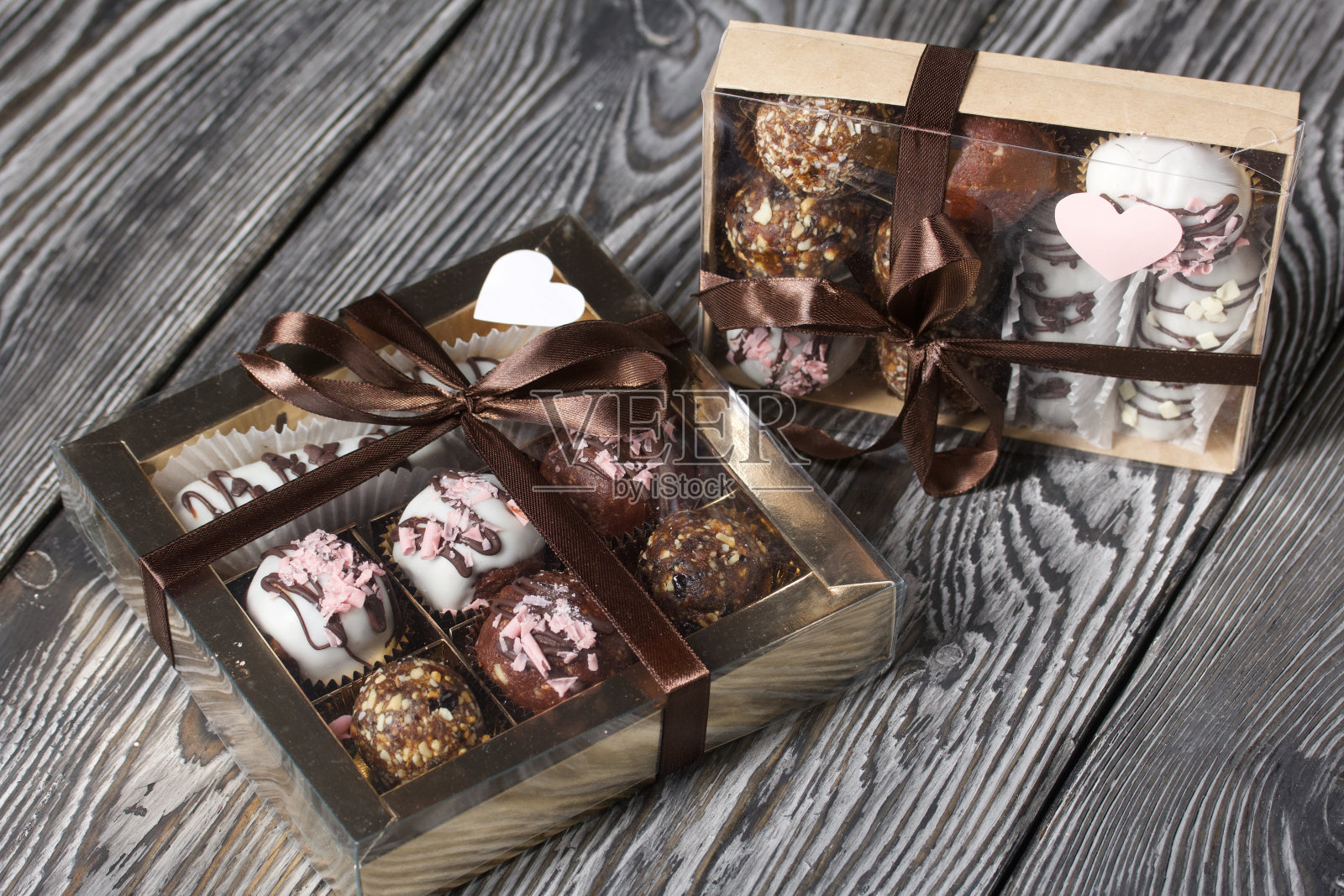 巧克力糖。在礼品盒里。用丝带系成一个蝴蝶结。松木板。照片摄影图片