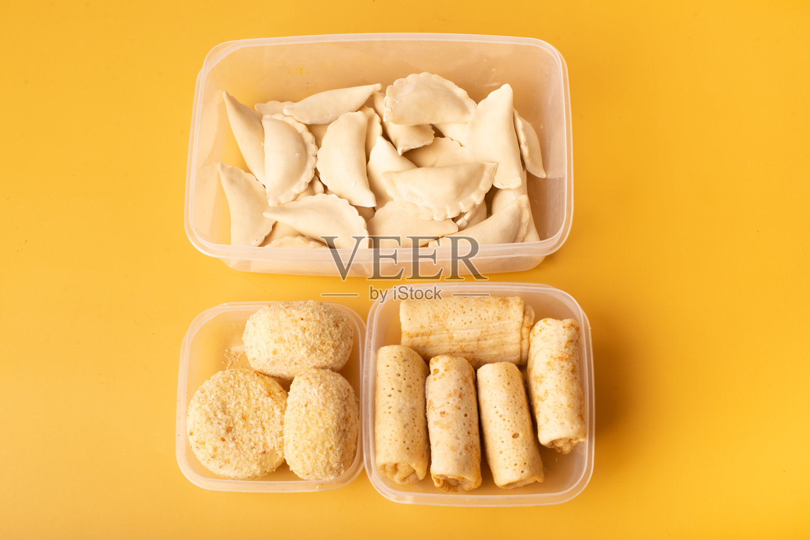 在黄色背景的容器中冷冻的半成品照片摄影图片