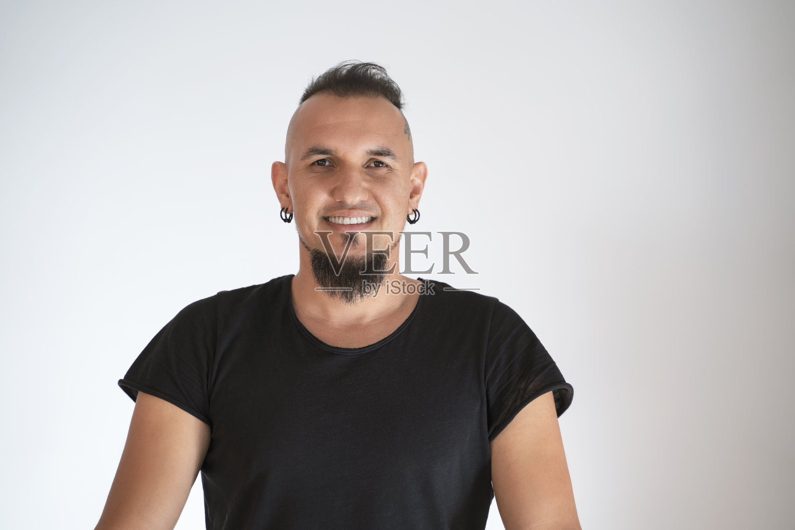 年轻男子的头像，头上有纹身，留着时髦的头发和胡子，身穿黑色t恤照片摄影图片