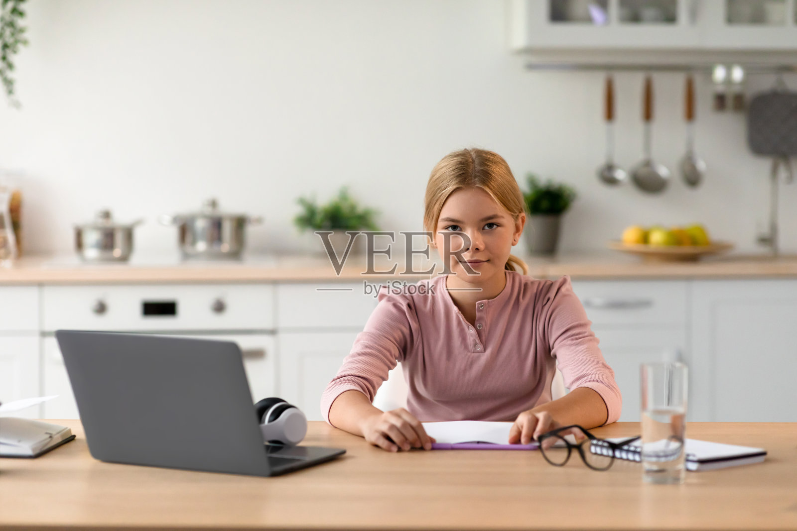 严肃可爱漂亮的欧洲年轻金发女孩准备在桌子上用笔记本电脑上课照片摄影图片
