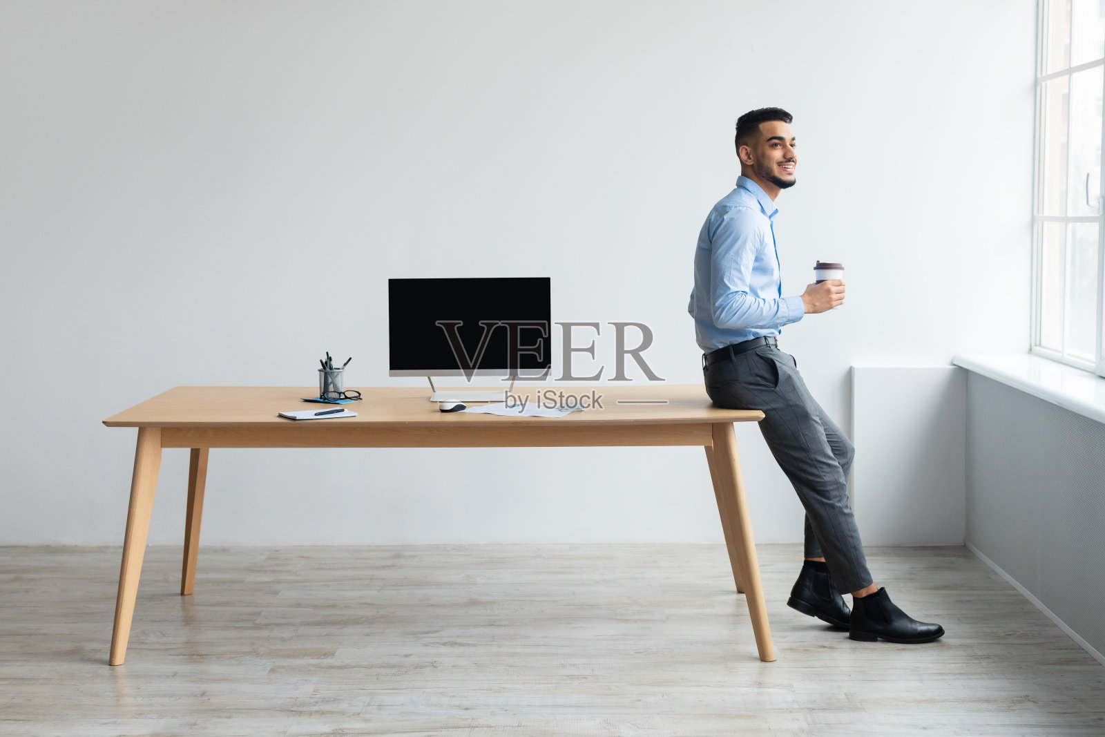 阿拉伯工人展示笔记本电脑与黑色空屏幕，模型照片摄影图片