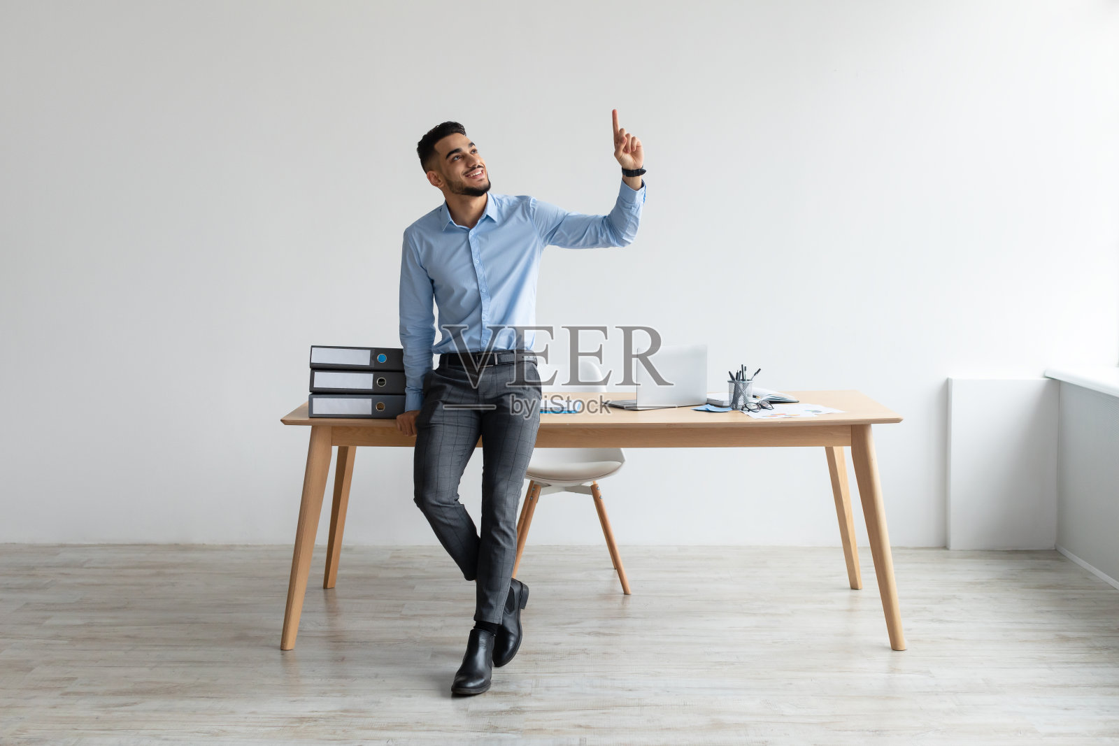 快乐商人在工作场所向上指手指照片摄影图片