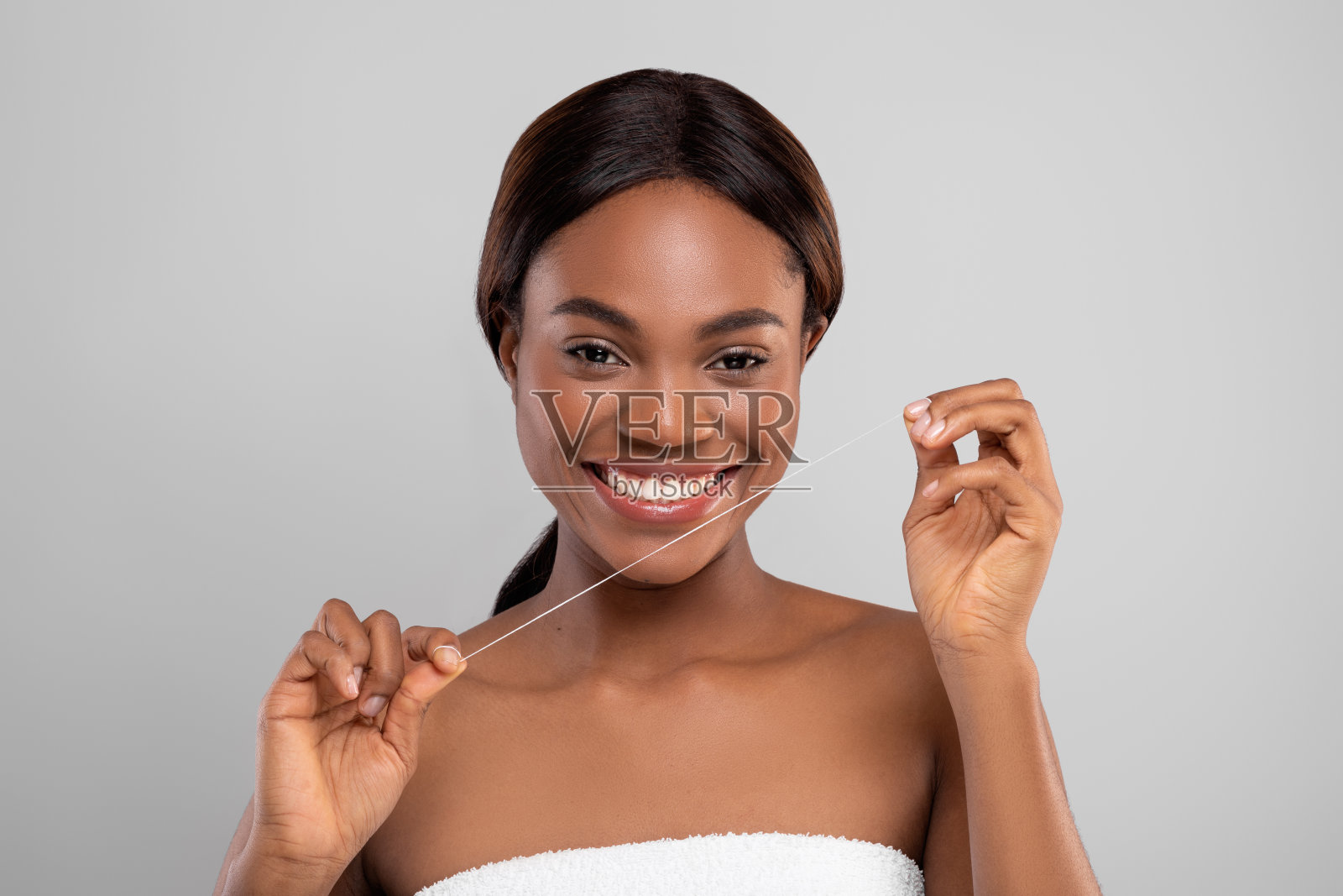 口腔护理。美丽的黑人女性使用牙线和对着镜头微笑照片摄影图片