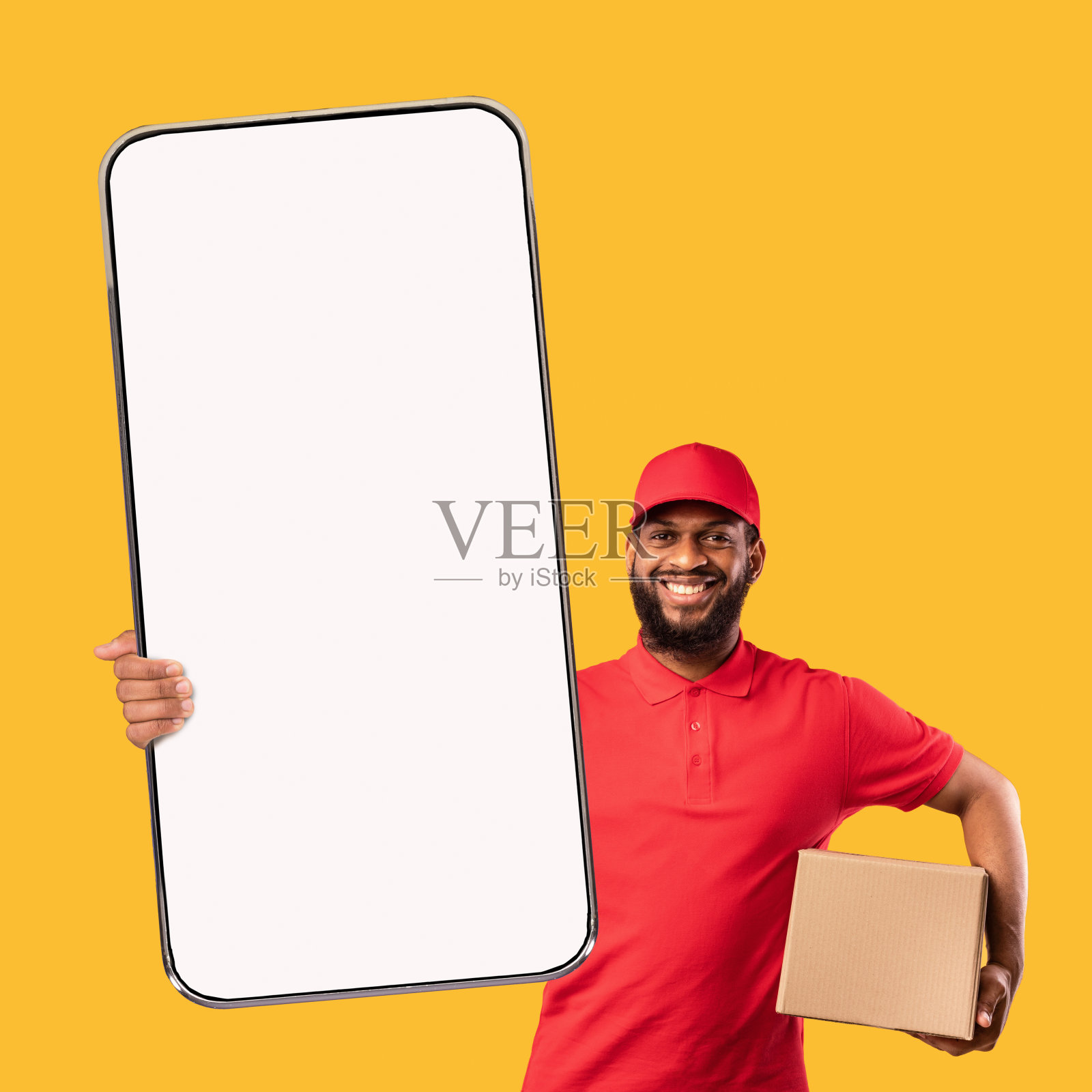 蓄着胡子的黑人送货员拿着纸板箱演示手机的空白屏幕照片摄影图片