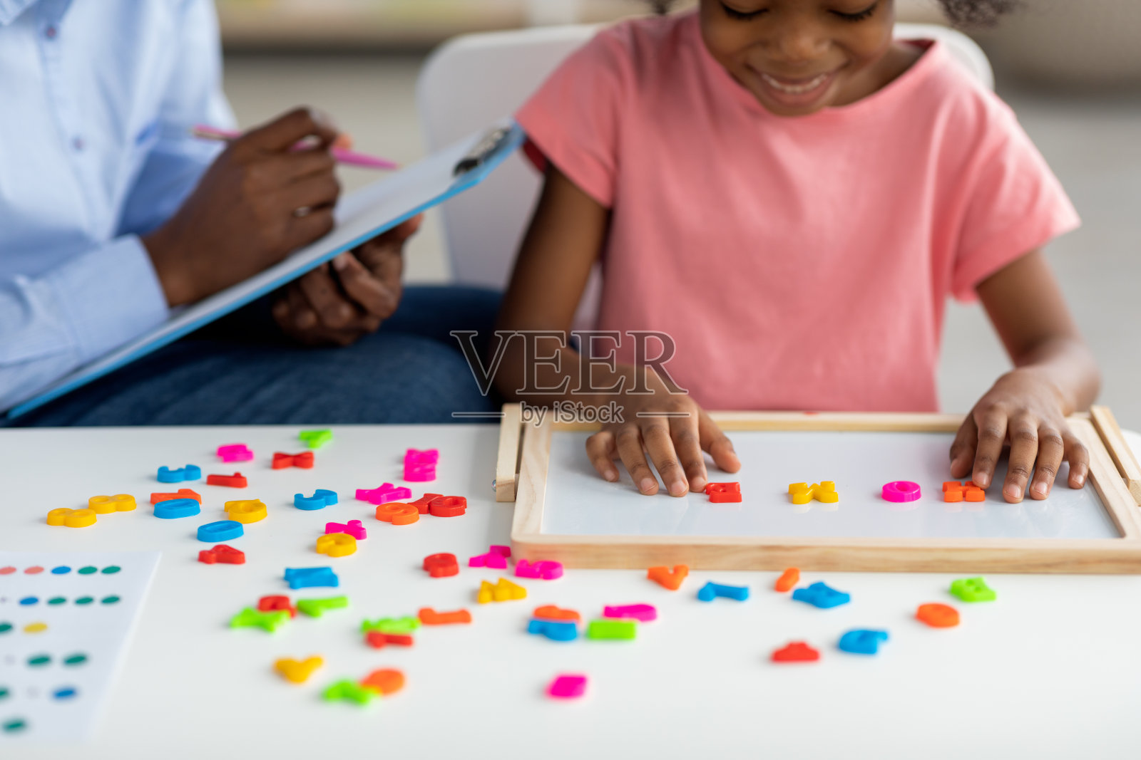 无法辨认的黑人女孩与女性儿童发展专家锻炼照片摄影图片