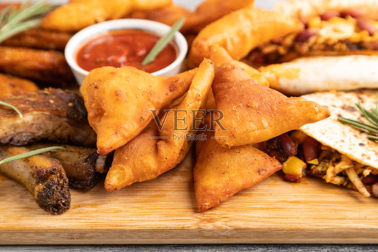 一套小吃:玉米片，鸡翅，炸排骨，玉米饼。侧视图，选择性聚焦。照片摄影图片