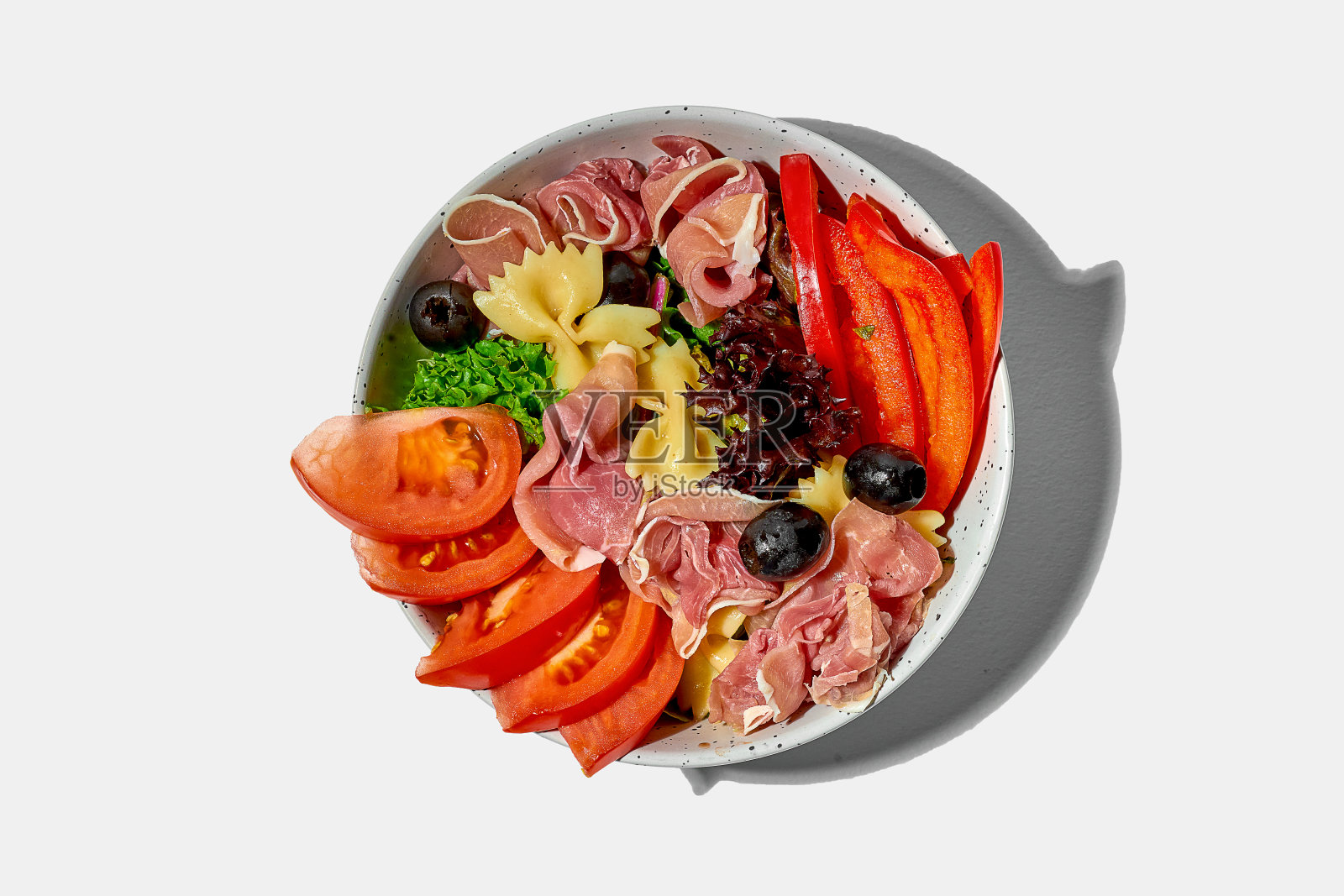 意大利通心粉配意大利熏火腿，西红柿，橄榄在碗里，白色背景照片摄影图片