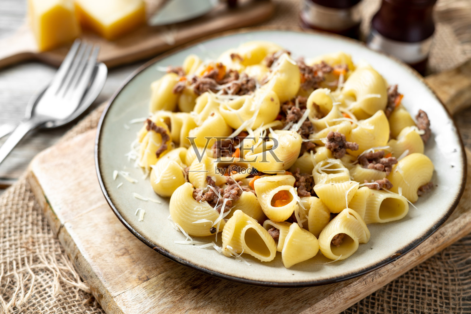 在Bianco的一个盘子上灰色的烹饪背景。厨房桌子上的传统意大利面和碎牛肉的特写照片摄影图片