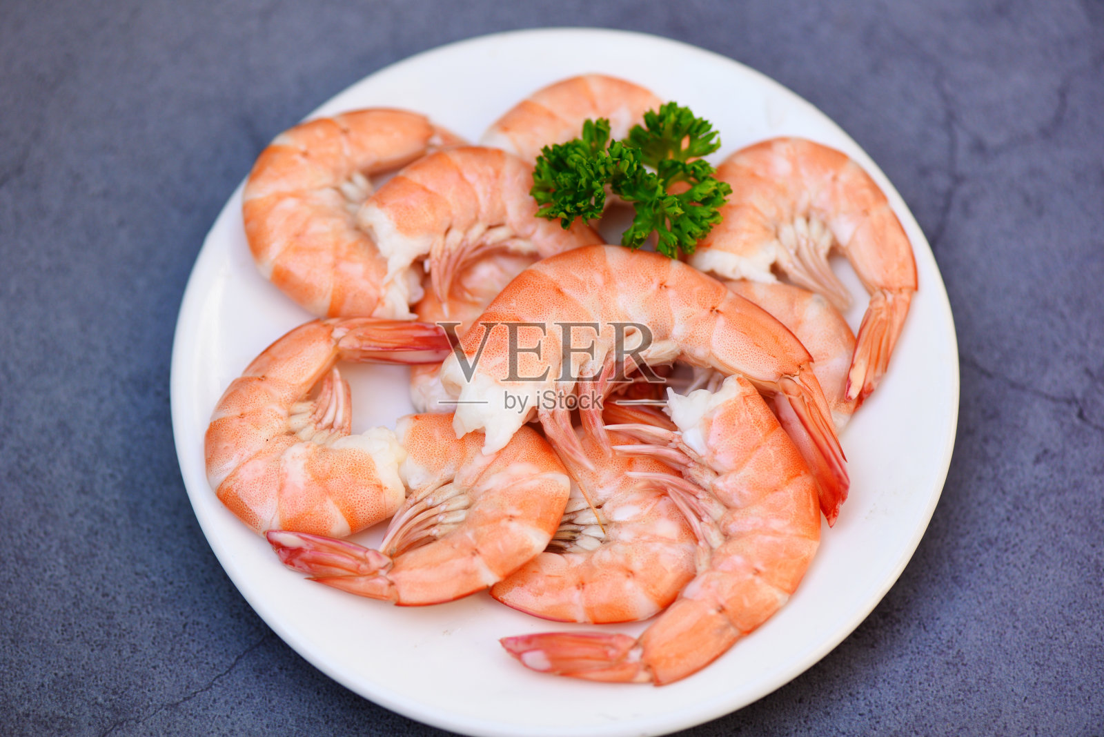 鲜虾配欧芹，煮熟去皮虾，在海鲜餐厅烹制照片摄影图片