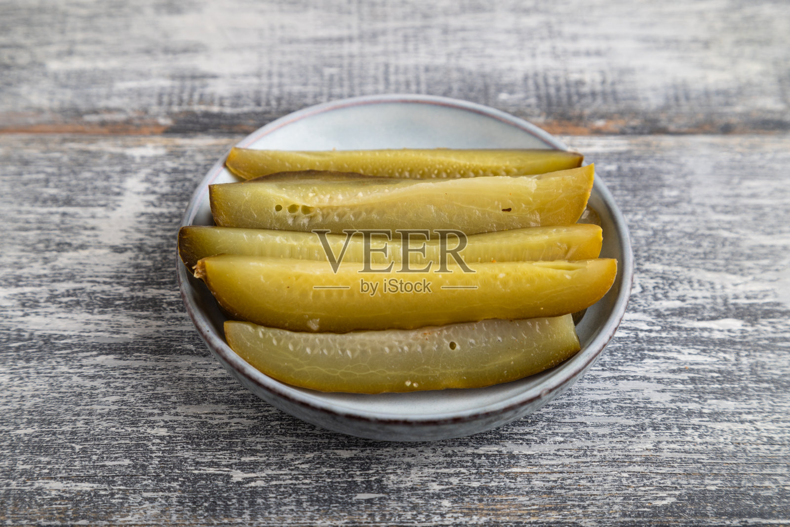 腌黄瓜在灰色的木质背景上。侧视图，特写。照片摄影图片