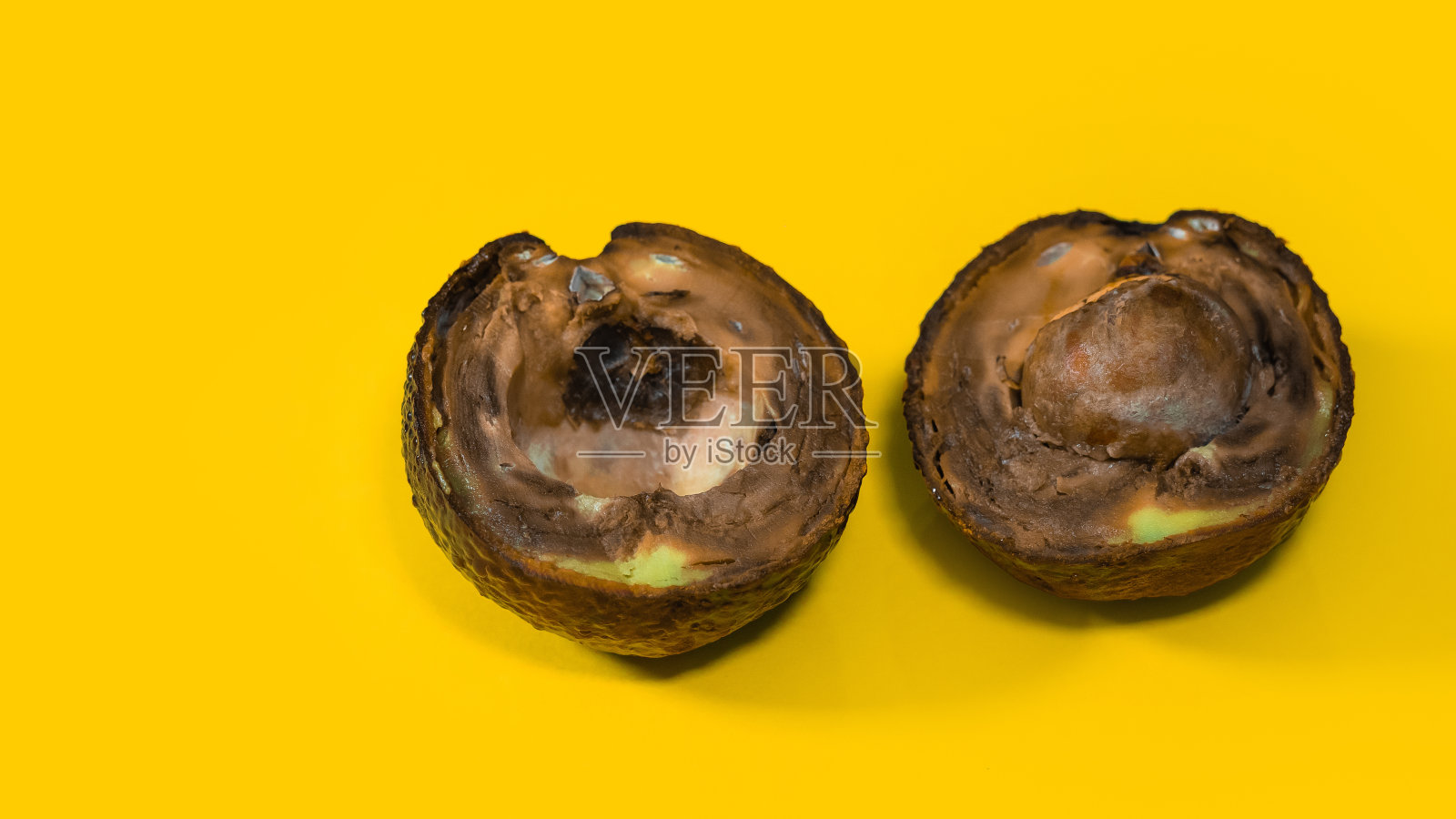 腐烂的鳄梨黄色背景。照片摄影图片