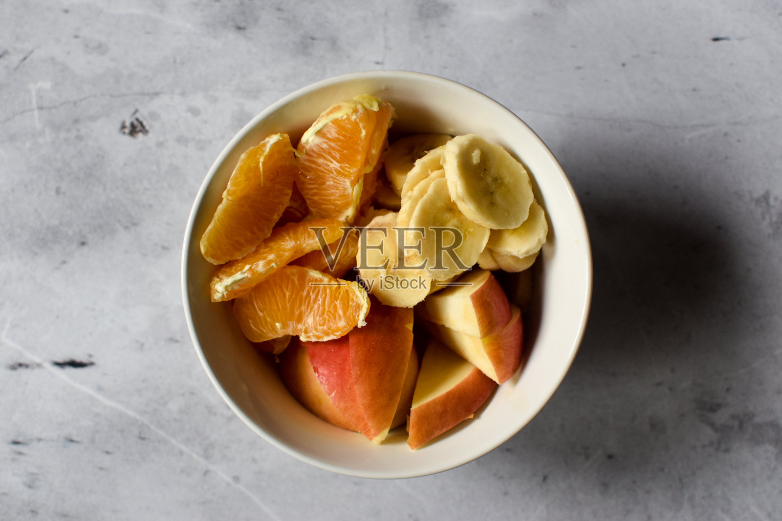 桌上的碗上放着香蕉皮、苹果皮和橘子皮照片摄影图片